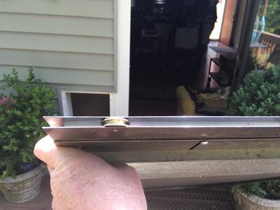 Adjustable screen door showing rollers